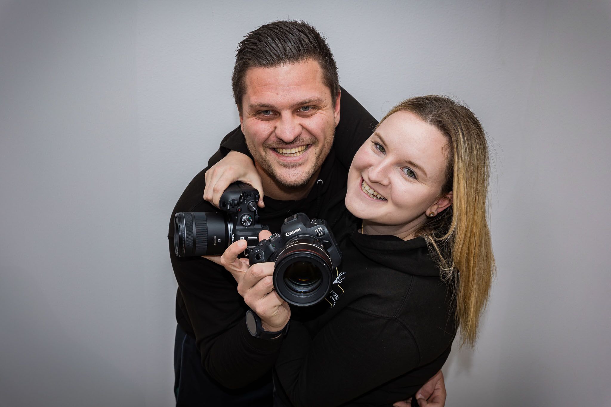 Eure Hochzeitsfotografen aus Bayern Shanice & Thomas mit Ihren Kameras im Profil lachen euch an.
